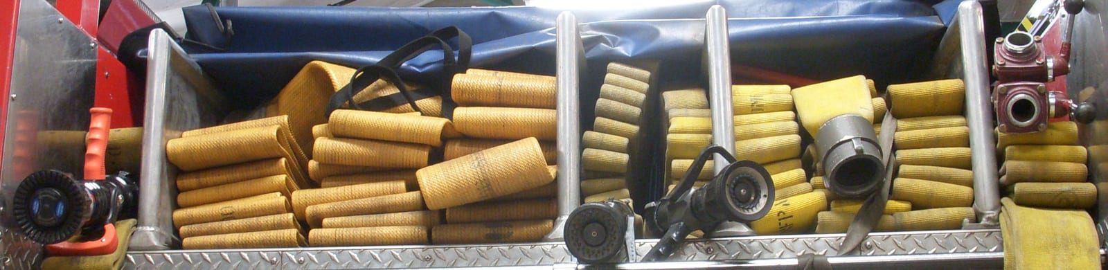 The hose bed of a fire engine: rolled attack lines and a flat load of supply hose.